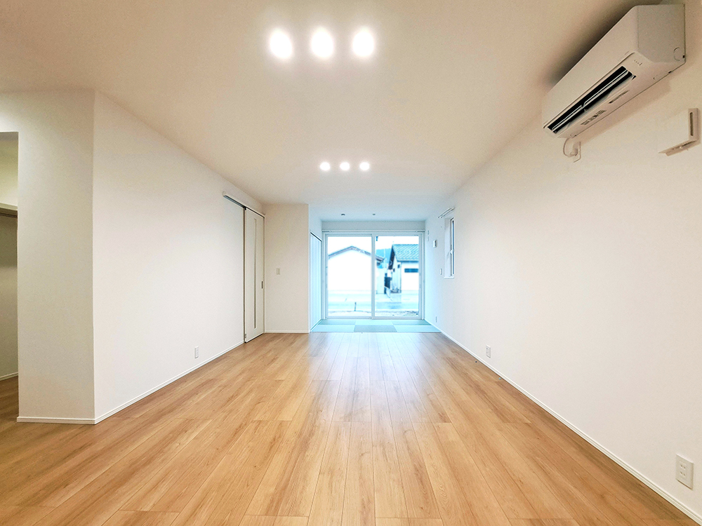 【現地内観(リビング)】キッチンからダイニング、リビングへと一直線につながる間取り。視線が抜けて、開放感たっぷり。家族の気配を感じながら過ごせるLDKです。